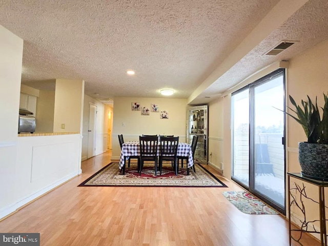 dining area with hardwood / wood-style flooring and a textured ceiling