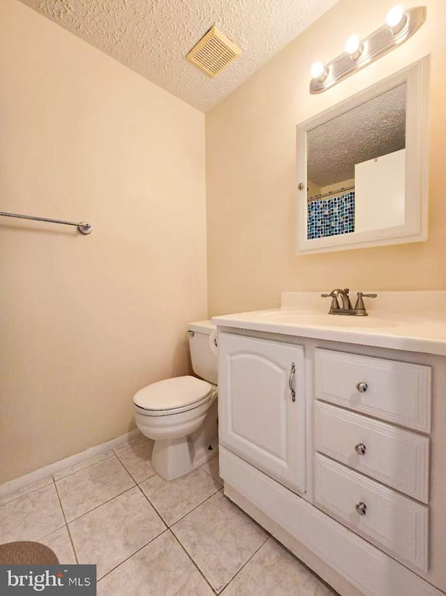 bathroom with vanity, tile patterned floors, a textured ceiling, and toilet