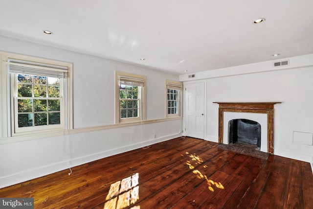 unfurnished living room with hardwood / wood-style floors and a healthy amount of sunlight