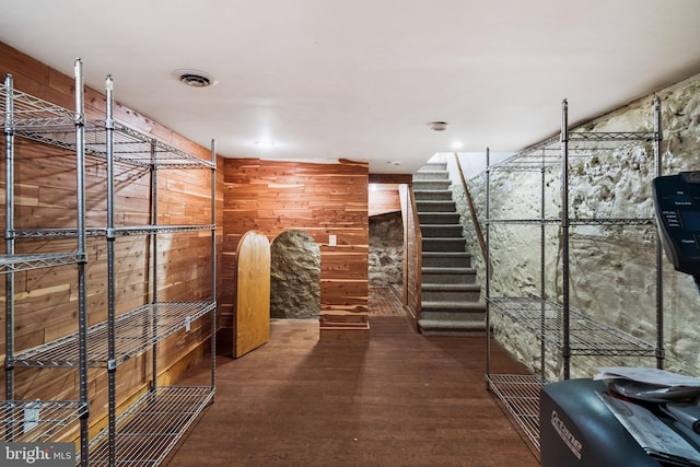 wine area with hardwood / wood-style flooring and wood walls