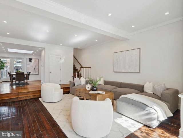 living room featuring hardwood / wood-style floors, ornamental molding, and a skylight