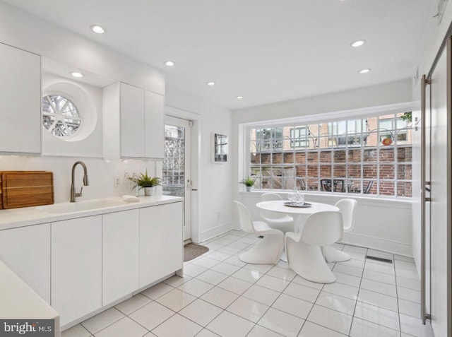 kitchen with sink, white cabinetry, and light tile patterned floors