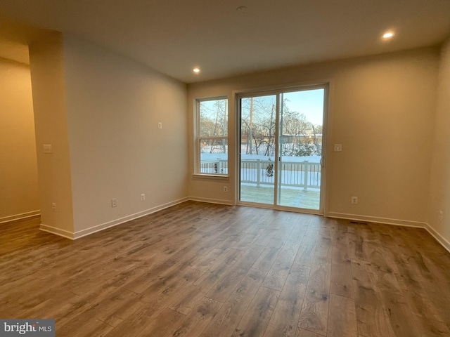 empty room with dark hardwood / wood-style flooring