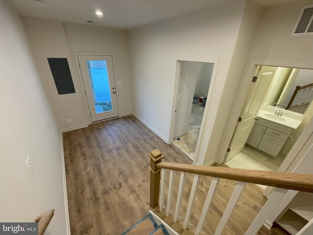 entryway with sink, light hardwood / wood-style flooring, and electric panel