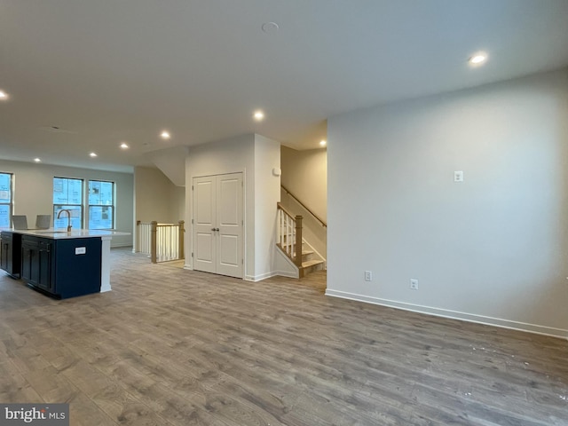 kitchen featuring sink, hardwood / wood-style flooring, and an island with sink