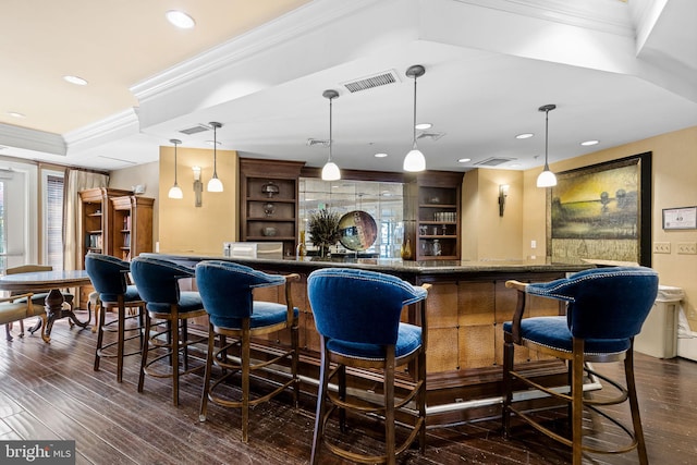 bar with hanging light fixtures, ornamental molding, dark hardwood / wood-style floors, and built in shelves