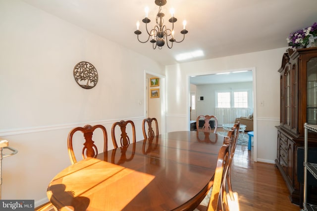 dining space with dark hardwood / wood-style flooring and a chandelier