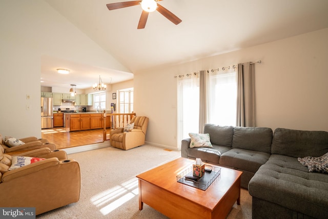 living room with ceiling fan with notable chandelier, sink, light colored carpet, and high vaulted ceiling