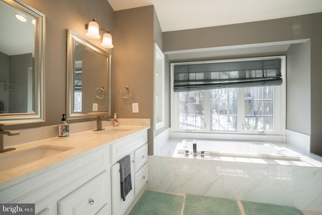 bathroom featuring vanity and a relaxing tiled tub