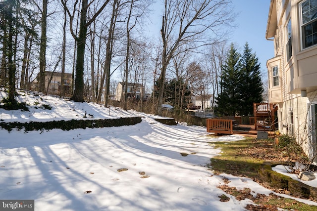 yard layered in snow with a wooden deck