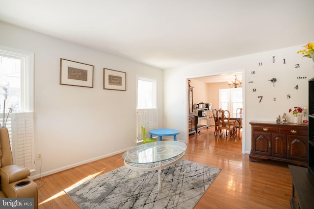 sitting room featuring a notable chandelier, a wealth of natural light, and light hardwood / wood-style floors