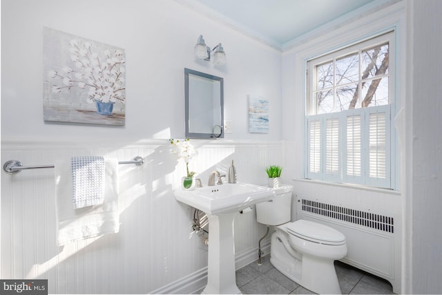 bathroom with tile patterned flooring, sink, radiator heating unit, and toilet