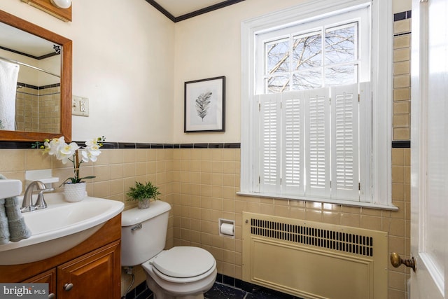 bathroom with toilet, tile walls, radiator heating unit, vanity, and curtained shower