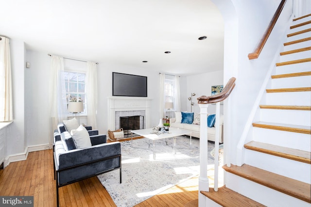 living room with a brick fireplace and light hardwood / wood-style floors