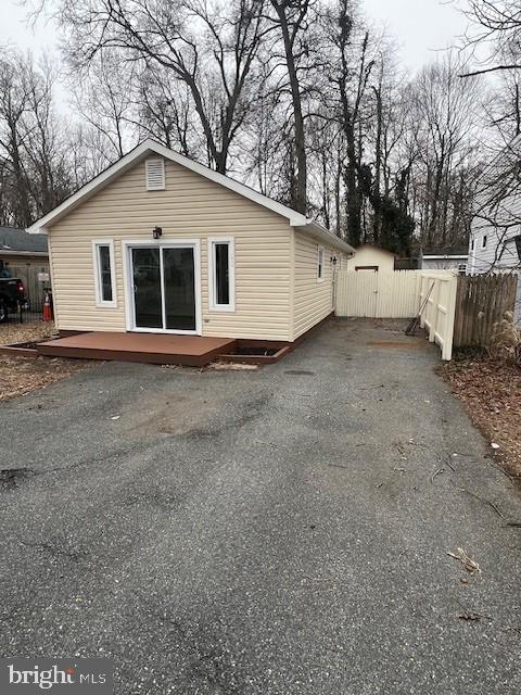 back of house with driveway and fence