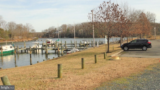 dock area with a lawn and a water view