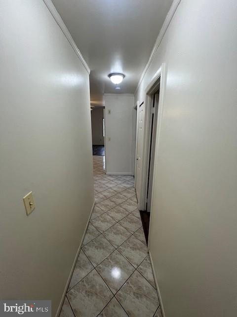 hallway featuring crown molding and baseboards