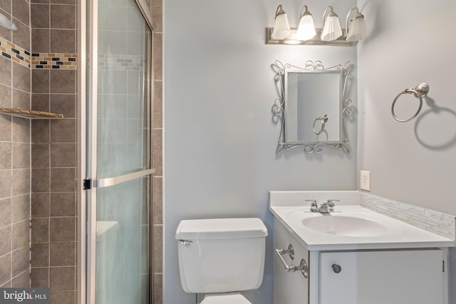 bathroom featuring vanity, toilet, and an enclosed shower