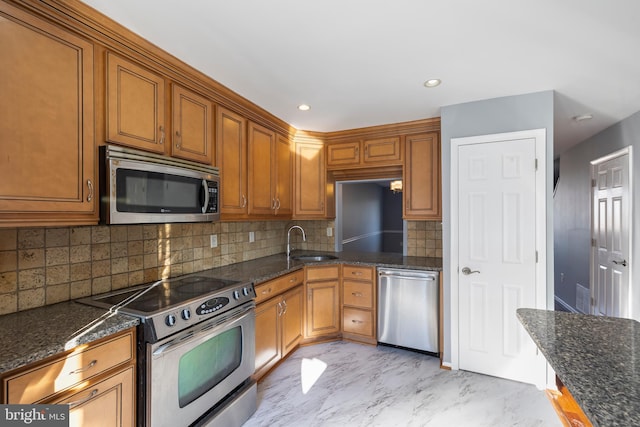 kitchen featuring sink, stainless steel appliances, dark stone countertops, and tasteful backsplash