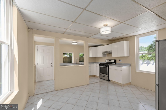 kitchen with white cabinets, a wealth of natural light, appliances with stainless steel finishes, and a drop ceiling