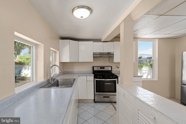 kitchen with sink, white cabinets, light tile patterned floors, and stainless steel appliances