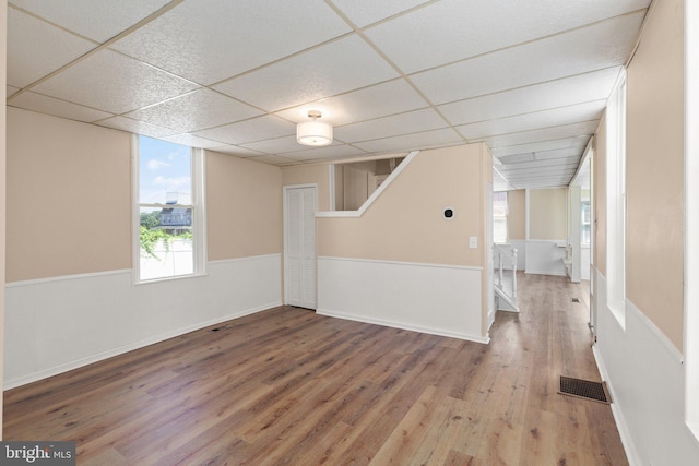 basement with wood-type flooring and a drop ceiling