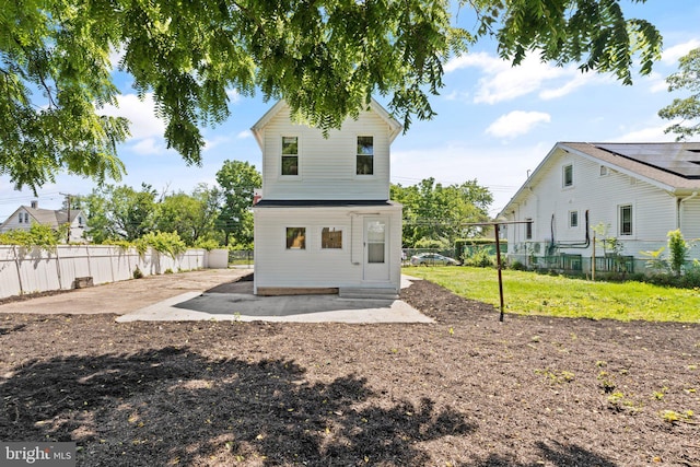 rear view of property featuring a lawn and a patio