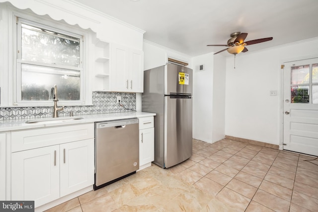 kitchen featuring sink, tasteful backsplash, ornamental molding, stainless steel appliances, and white cabinets