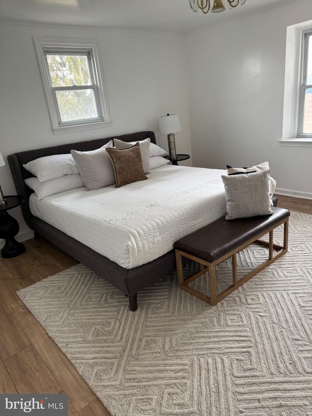 bedroom with ornamental molding and light hardwood / wood-style flooring