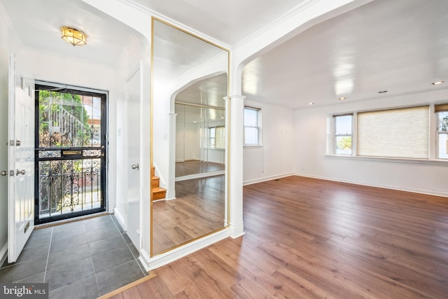 foyer entrance featuring dark wood-type flooring and ornamental molding