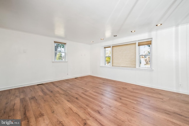 unfurnished room featuring ornamental molding and light hardwood / wood-style floors