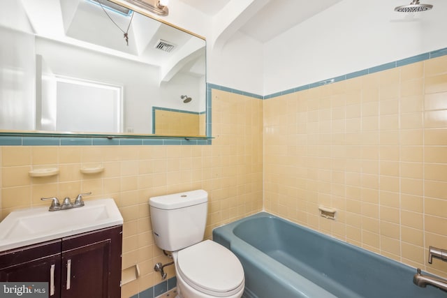 bathroom with tile walls, vanity, and toilet