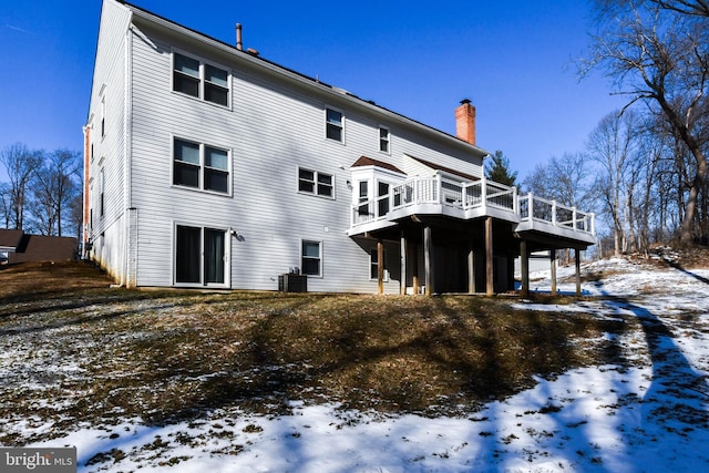 snow covered property featuring a deck and central AC unit