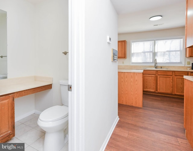 bathroom with sink, toilet, and hardwood / wood-style flooring