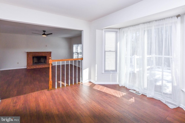 interior space with a fireplace, hardwood / wood-style flooring, and ceiling fan