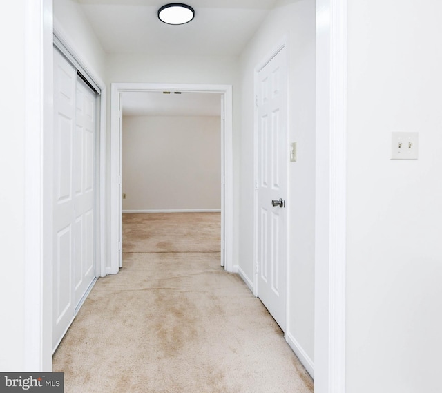 hall with light colored carpet