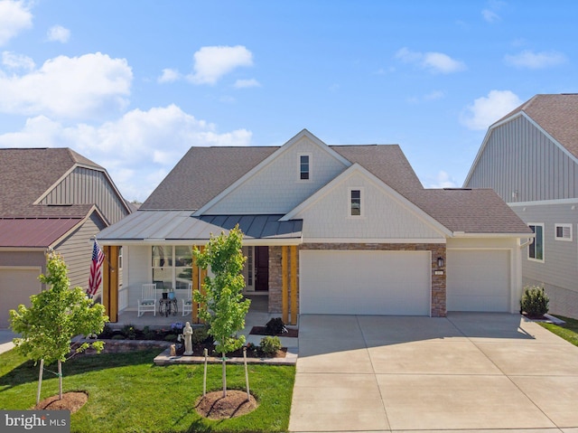 view of front of property featuring a garage, covered porch, and a front lawn