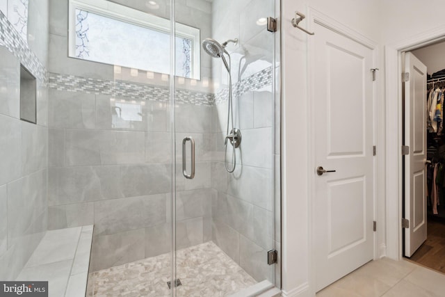 bathroom with an enclosed shower and tile patterned floors