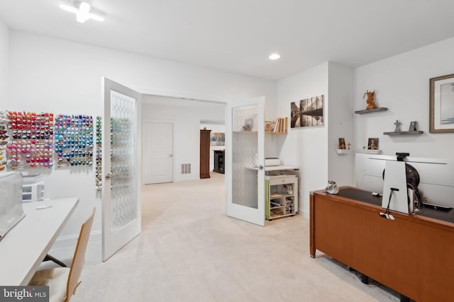 carpeted home office with french doors