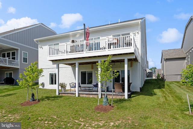 back of property with a deck, a patio, and a lawn