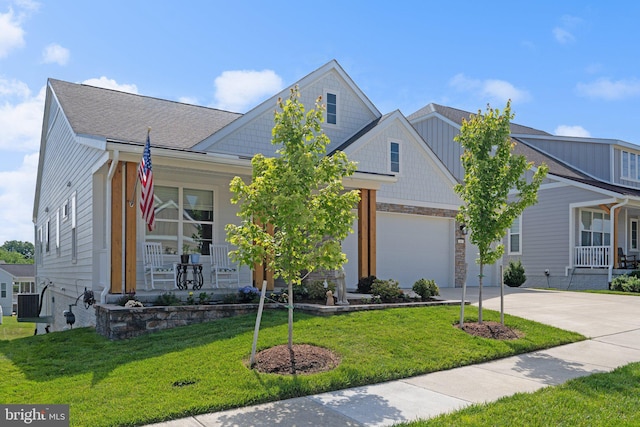 view of front facade featuring a garage, a front yard, and covered porch