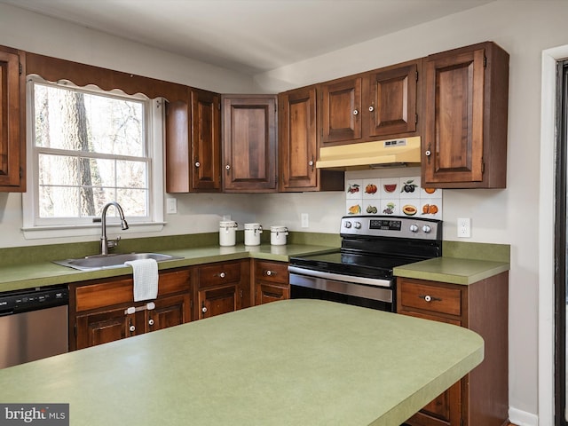 kitchen featuring under cabinet range hood, stainless steel appliances, a sink, and light countertops