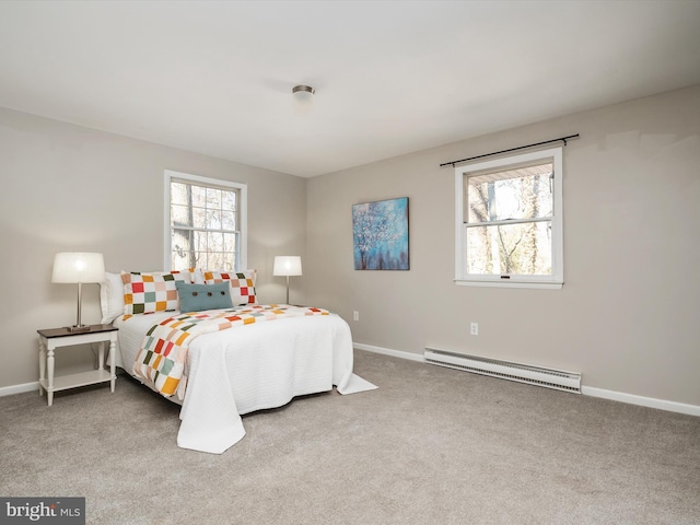 bedroom with a baseboard heating unit, carpet floors, and baseboards