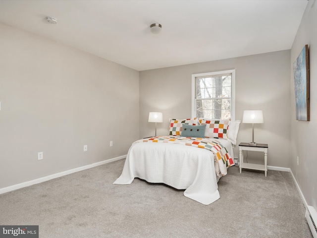 carpeted bedroom with baseboard heating and baseboards