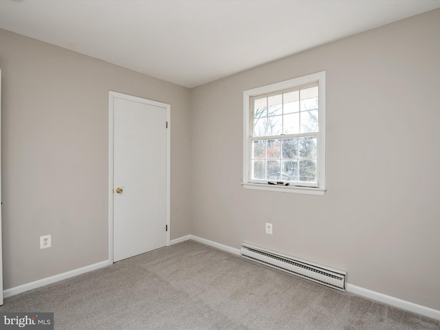 empty room featuring a baseboard radiator, carpet flooring, and baseboards