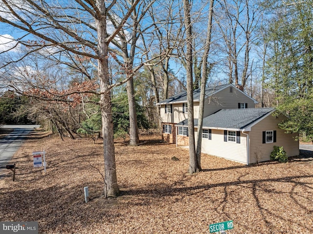 view of side of property with roof with shingles