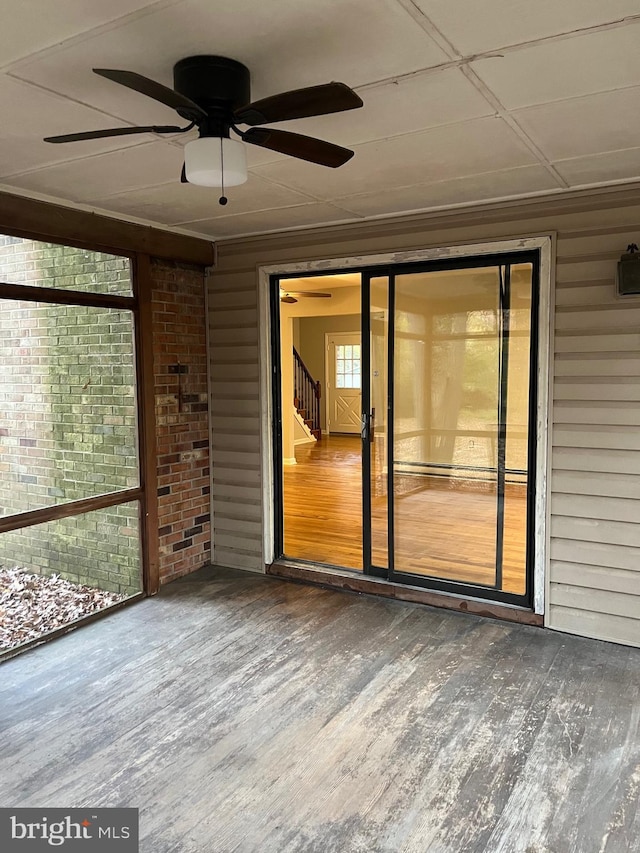 unfurnished sunroom featuring ceiling fan