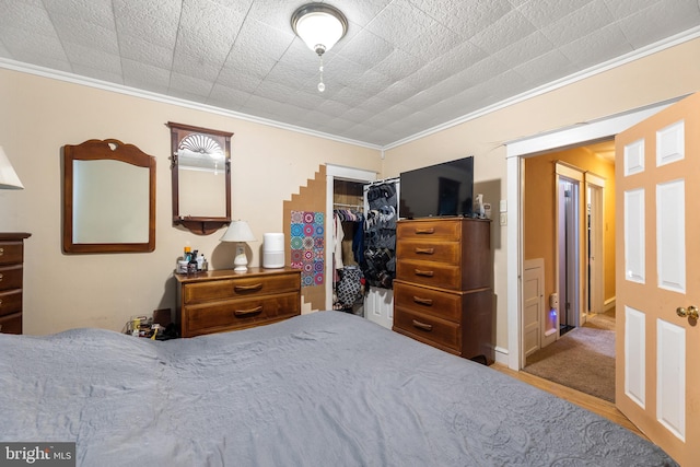 bedroom featuring crown molding and a closet