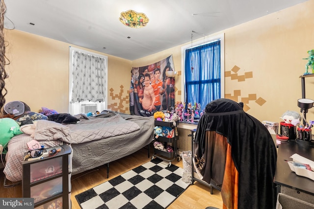 bedroom featuring wood-type flooring and cooling unit