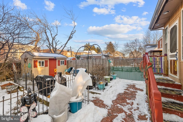 yard covered in snow featuring a shed